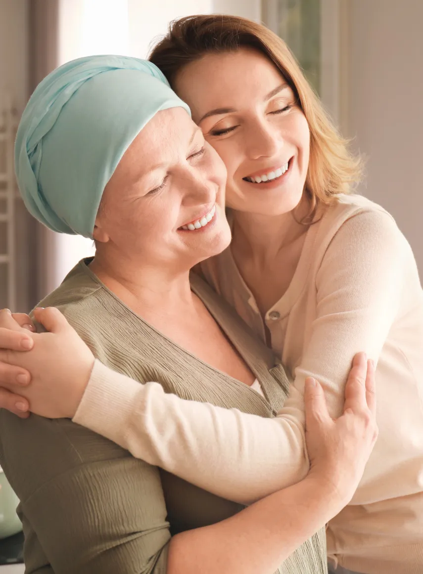 A woman in cancer treatment embraced by a loved one